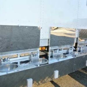A row of outdoor stainless steel sinks installed on a white commercial trailer