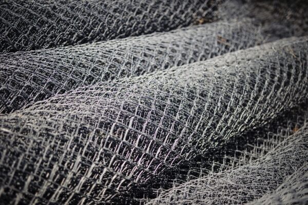 Close-up of rollup-up chainlink fences stacked next to each other