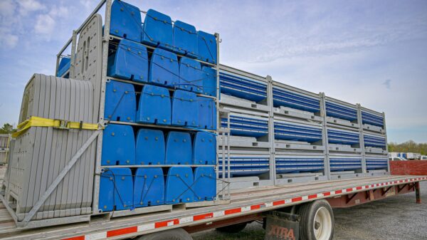 Hydroflow restroom pallets sitting on a flat-bed trailer mounted to a truck parked in a parking lot