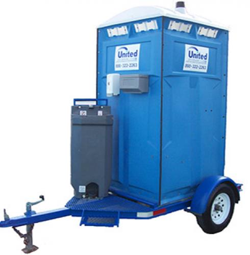 A blue trailer-mounted portable restroom mounted on a small single-axle trailer, featuring a handwashing station attached to its side