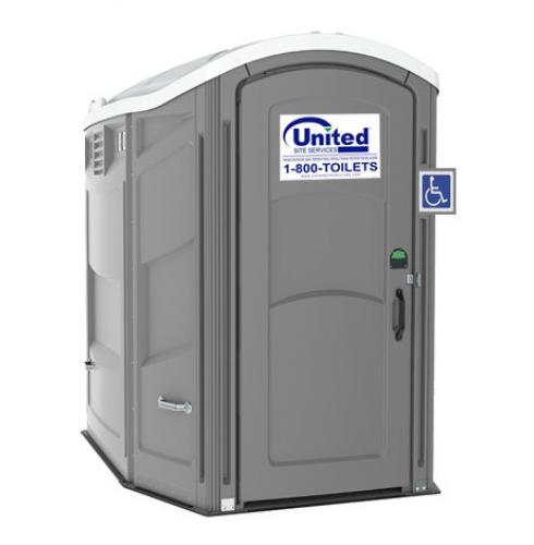 Gray portable toilet with a handicap access symbol and a logo reading "United Site Services 1-800-TOILETS" on a white sign